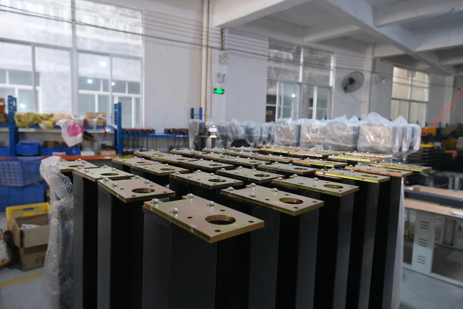 Rows of barrier gate cabinets with exposed drive mechanisms in the Hengbo workshop
