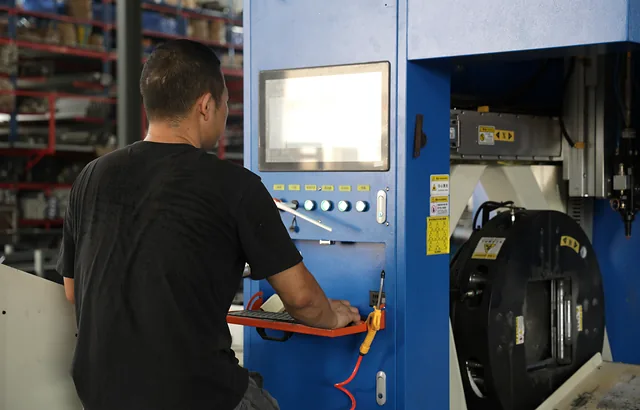 An operator working at a profile-processing machine in the Hengbo workshop