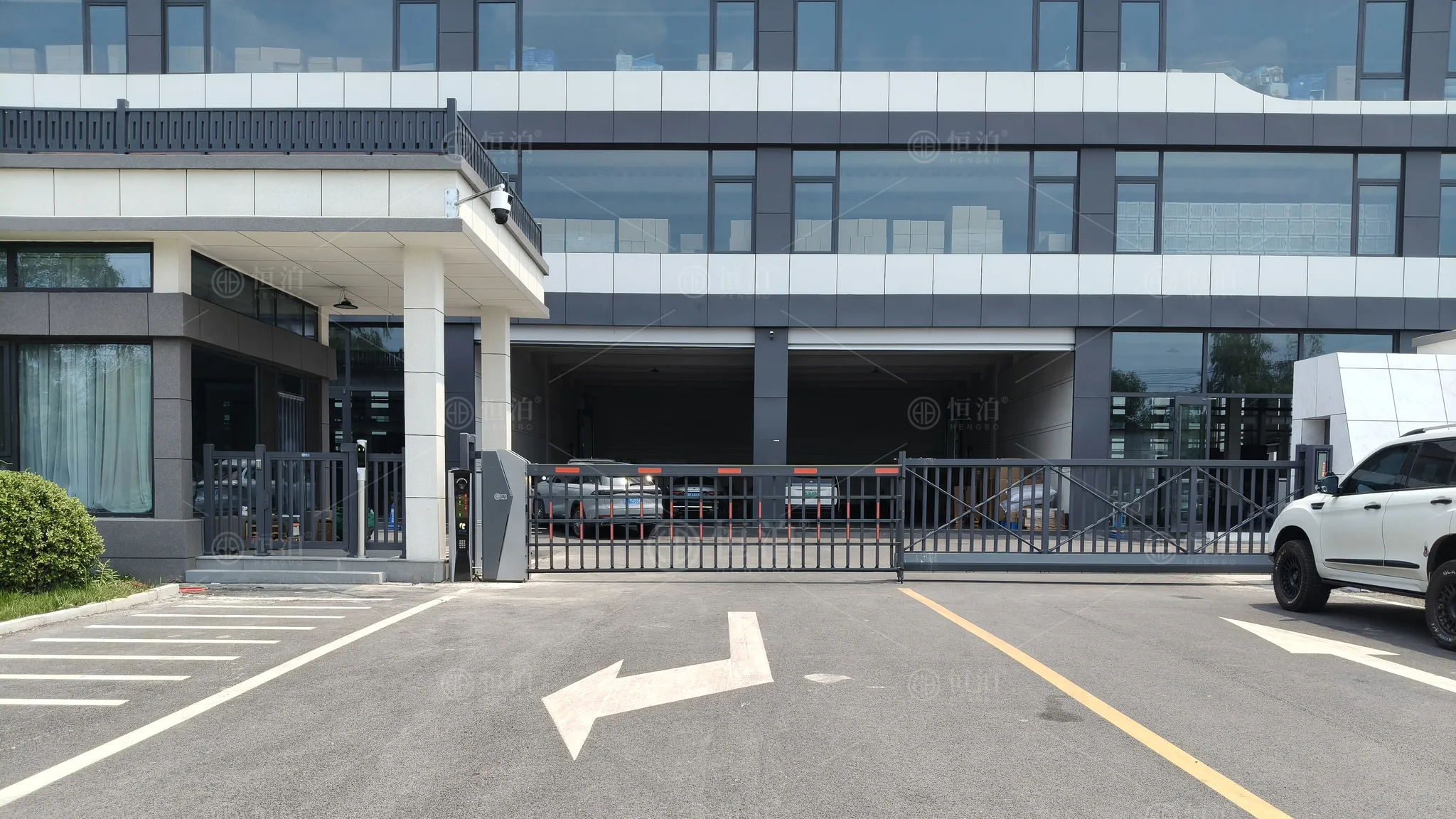 Installation photograph showing the building frontage, entrance equipment and marked vehicle approach